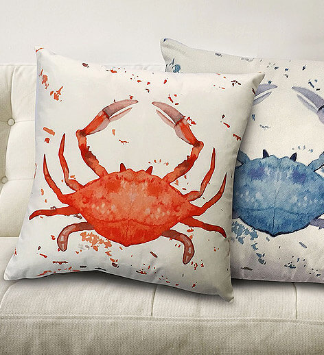 Two decorative pillows with crabs - one crab is red, the other crab is blue.
